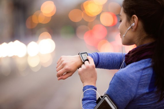 Frau mit Pulsuhr und Smartwatch beim Joggen