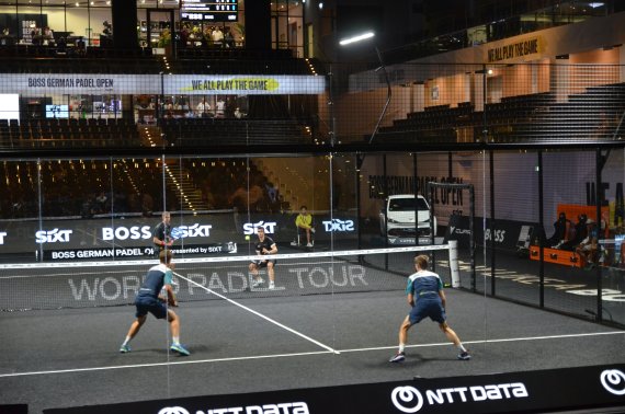 Vier Padel-Spieler auf einen Court mitten im Spiel