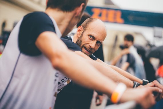 Zwei Männer dehnen sich nach einem Lauf