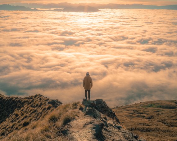 Person vor Wolkenmeer stehend