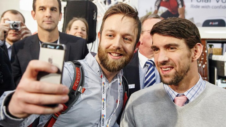 Ein Besucher macht ein Selfie mit Michael Phelps.