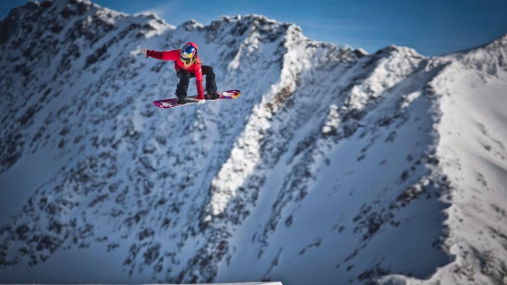 Anna Gasser in der Luft auf ihrem Snowboard.