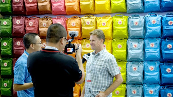 Bei Fjällraven wird vor der klassischen Regenbogen-Rucksack-Wand noch auf die Videobotschaft gesetzt 