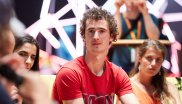 Adam Ondra sitzt zwischen Menschen