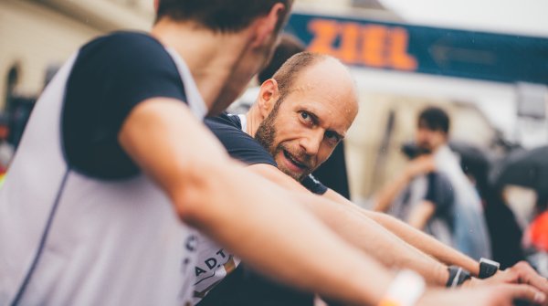 Zwei Männer dehnen sich nach einem Lauf