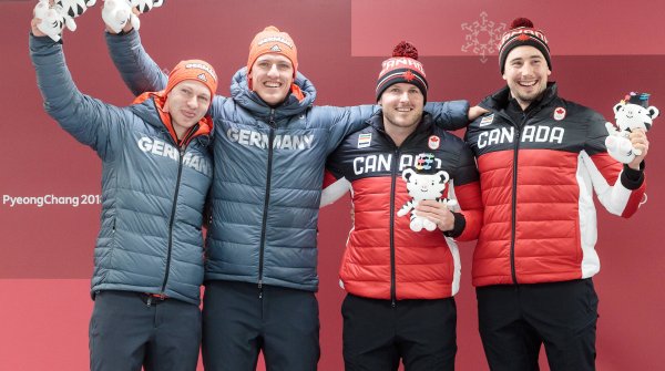 Francesco Friedrich, Thorsten Margis und die kanadischen Piloten freuen sich über gemeinsames Gold