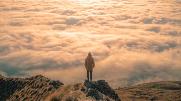 Person vor Wolkenmeer stehend