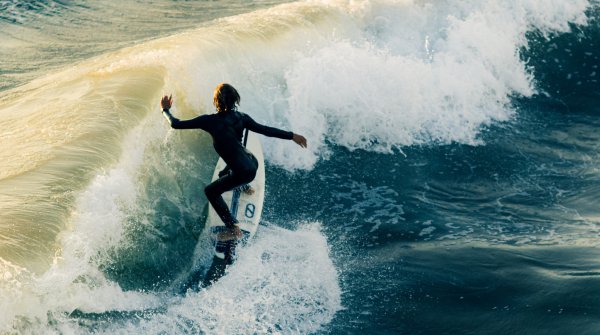 Surferin fährt auf eine Welle zu